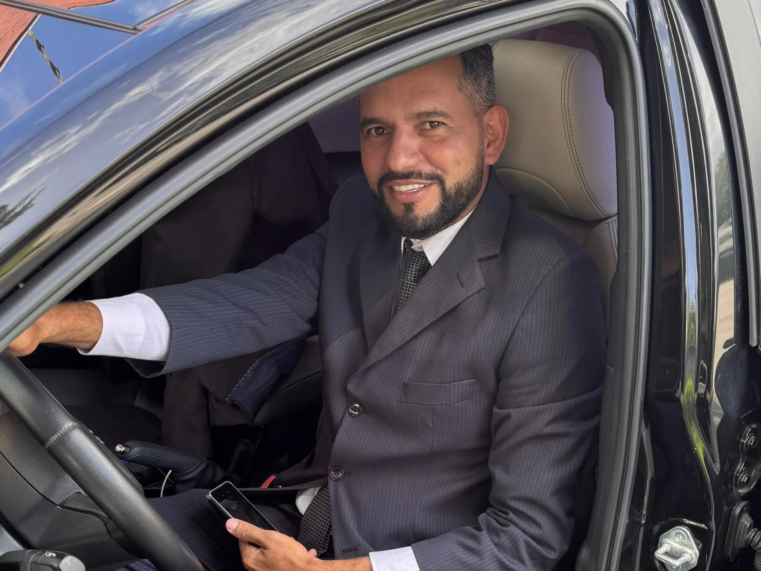 Motorista executivo abrindo a porta do carro